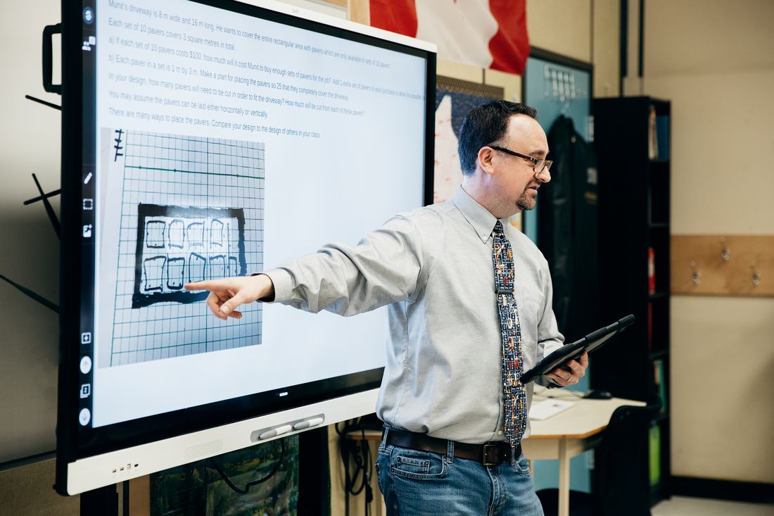 A teacher leading a lesson on a SMART interactive display